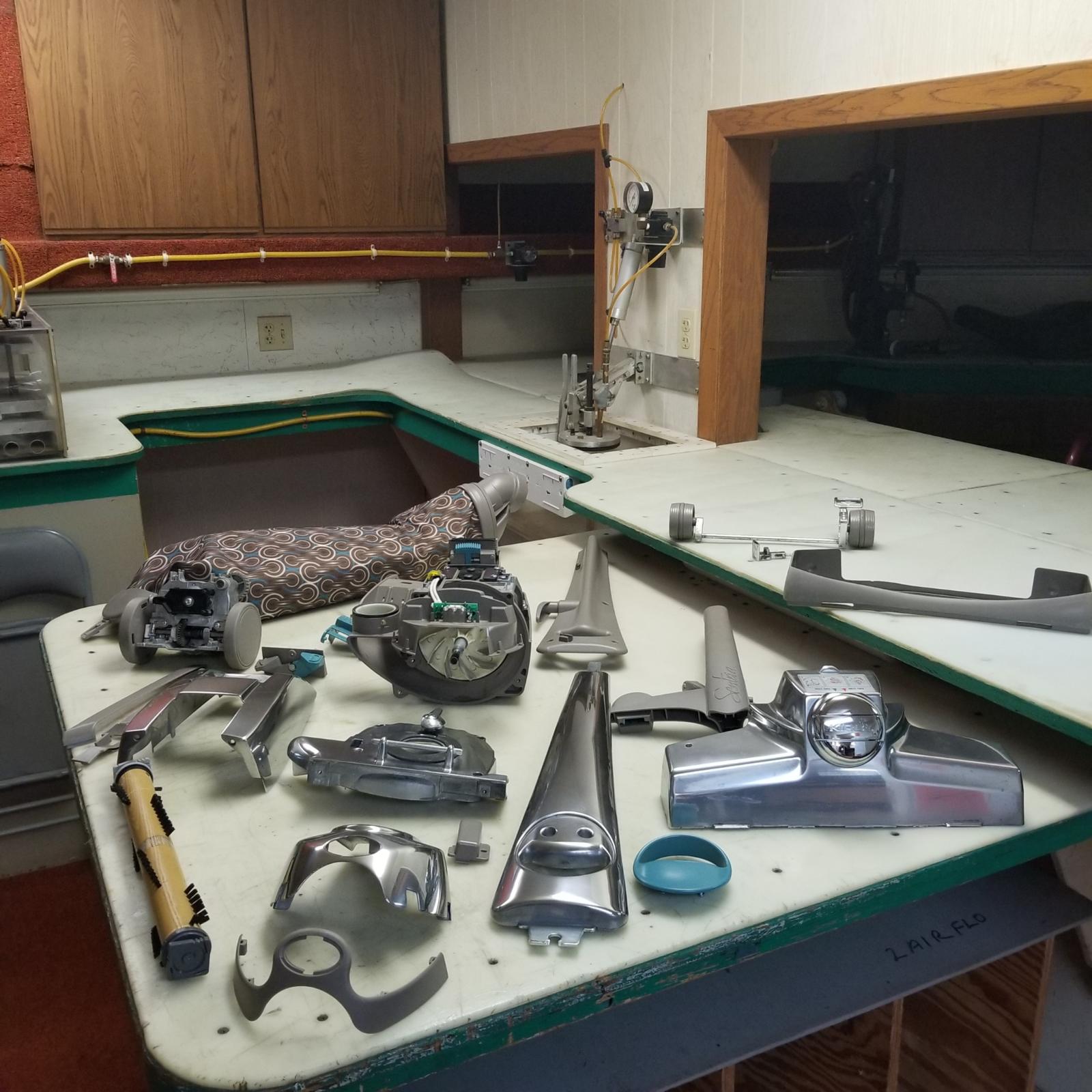 A Kirby stripped down into its parts on the repair bench